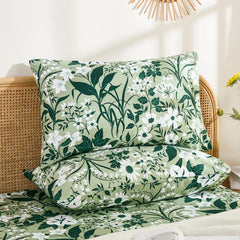 Two olive green floral cotton pillowcases stacked neatly, showcasing the intricate white flower and dark green foliage pattern.