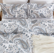 overhead flat lay shot of the coastal heritage paisley duvet set with a cream fringe throw