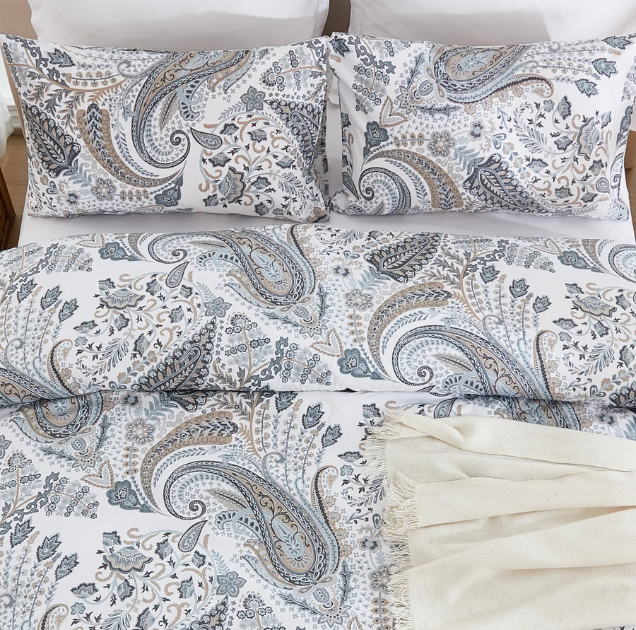 overhead flat lay shot of the coastal heritage paisley duvet set with a cream fringe throw