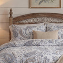 detailed view of dusty blue paisley print cotton pillow shams on a classic wooden bed frame