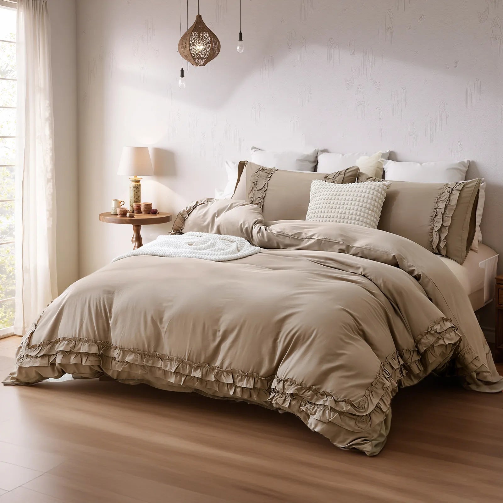 Full view of the swarm greige comforter styled on a bed in a bright bedroom.