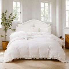 A white cotton bedding set with ruffle  trim detailing on the duvet cover and pillowcases.
