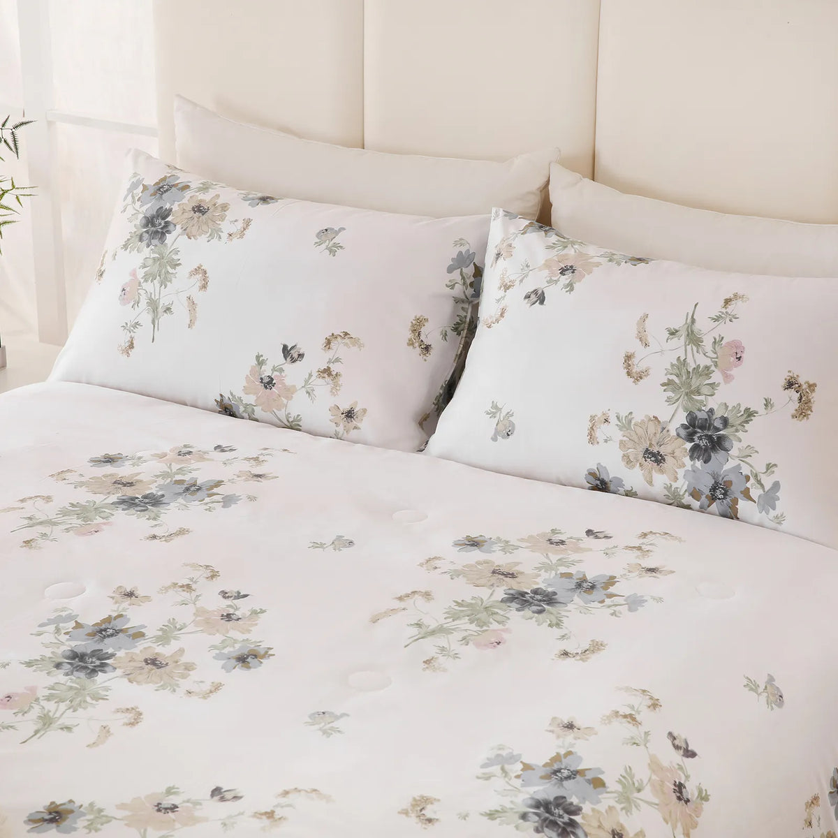 Close-up of white floral comforter and pillows with subtle texture