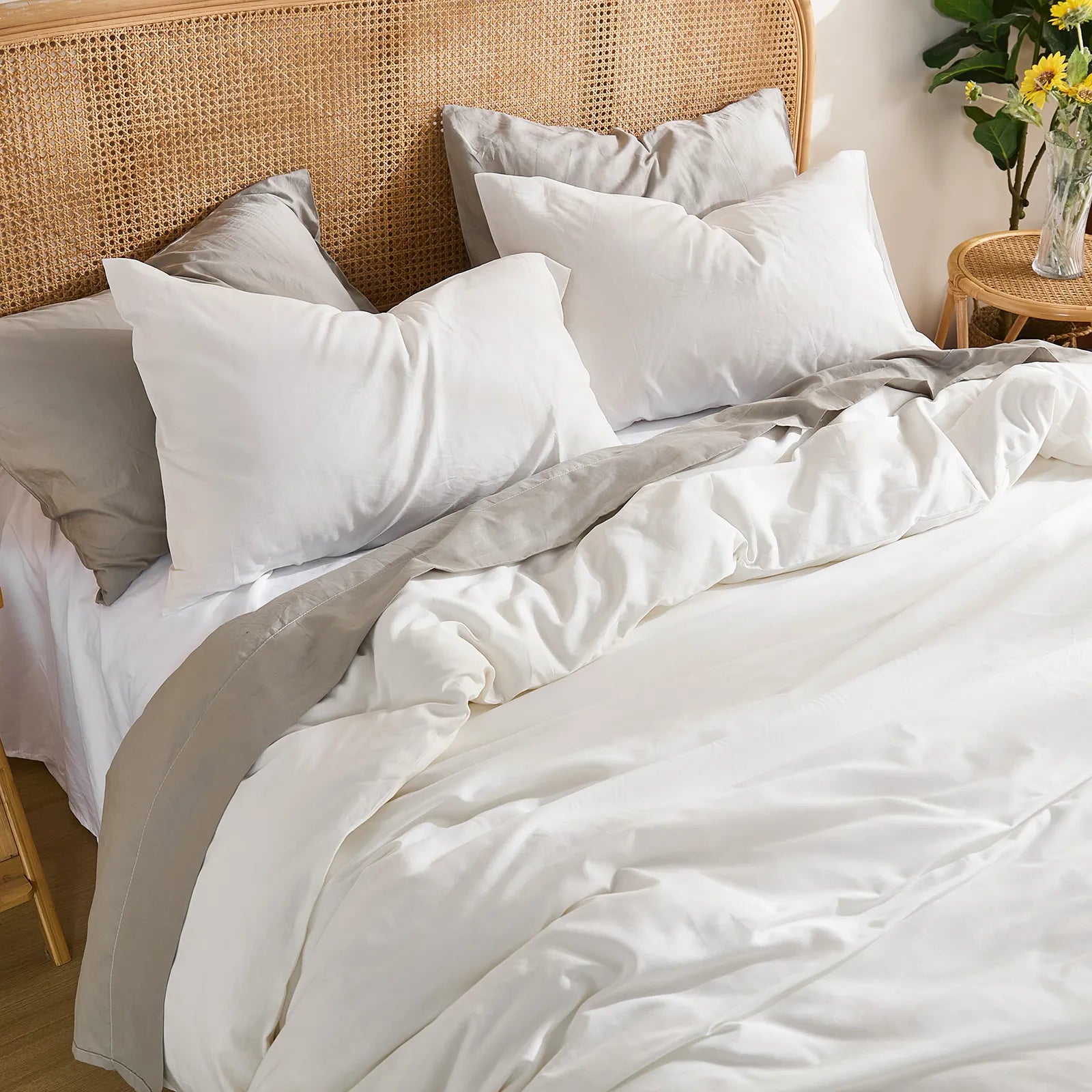 Overhead angled shot from the foot of the bed showing the white duvet's natural folds and the pillow arrangement.