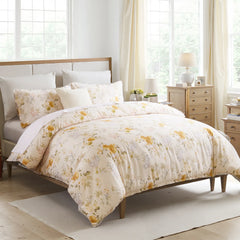 Yellow floral comforter set styled on a bed in a light and airy bedroom