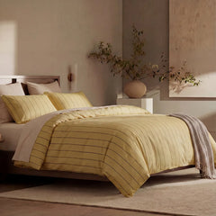 Angled shot of yellow striped duvet cover on bed